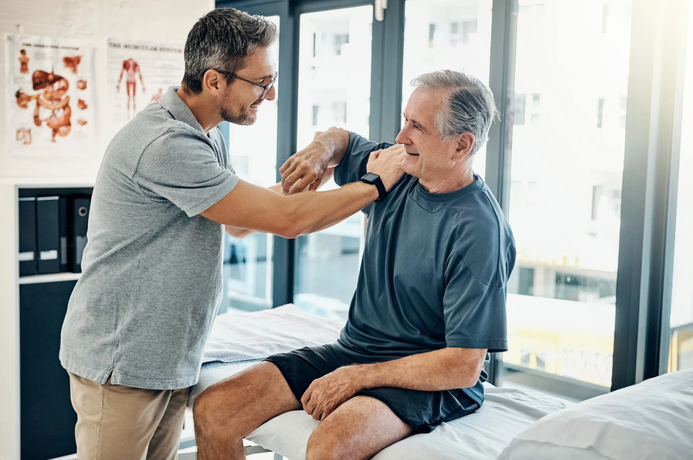 Physical therapist examining a patient's shoulder in a bright clinical setting
